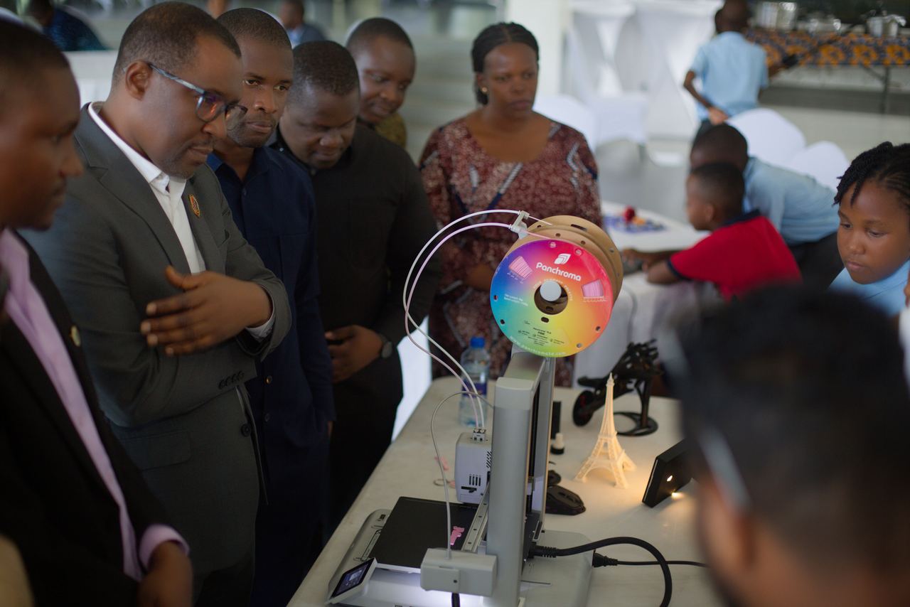 Guest of honour observing a 3D printer at the student exhibition