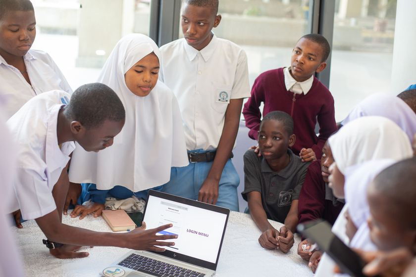 Students demonstrating a login menu application on a laptop